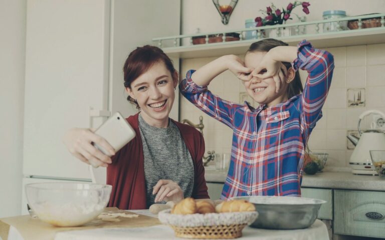 Mutter und Tochter lachen gemeinsam in der Küche